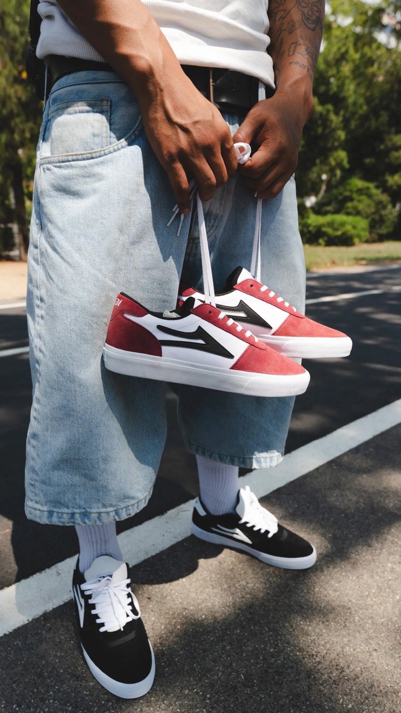 Skater holding a pair of red and white Lakai Manchesters