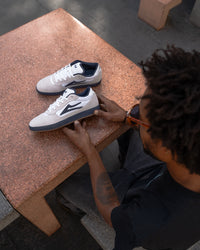 Skater wearing Lakai Cambridge XLK skate shoes in White Suede Navy Gum